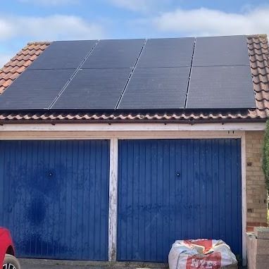 A garage with blue doors and solar panels on the roof.