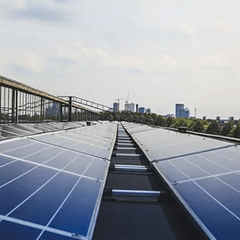 A row of solar panels on the roof of a building.