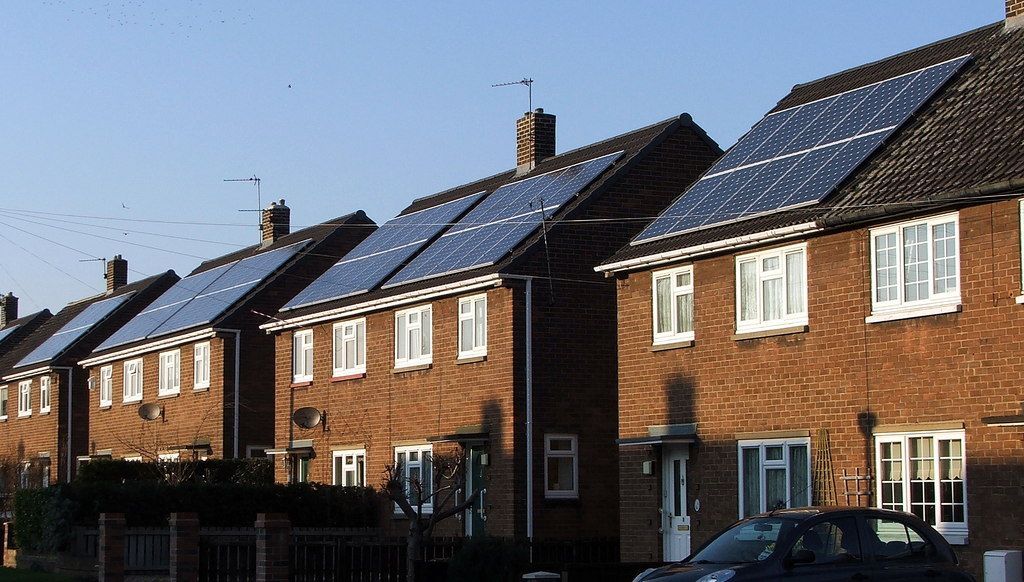 A row of houses with solar panels on the roofs