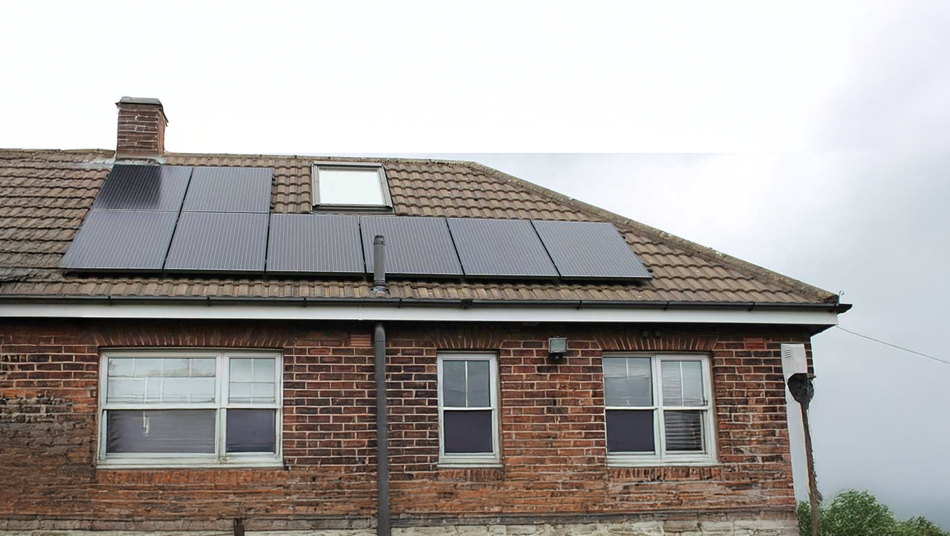 A brick house with solar panels on the roof.