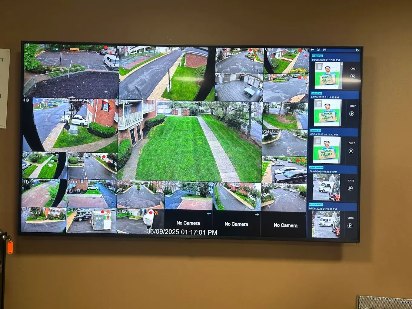 Flat-screen monitor displaying multiple security camera views of a residential area.