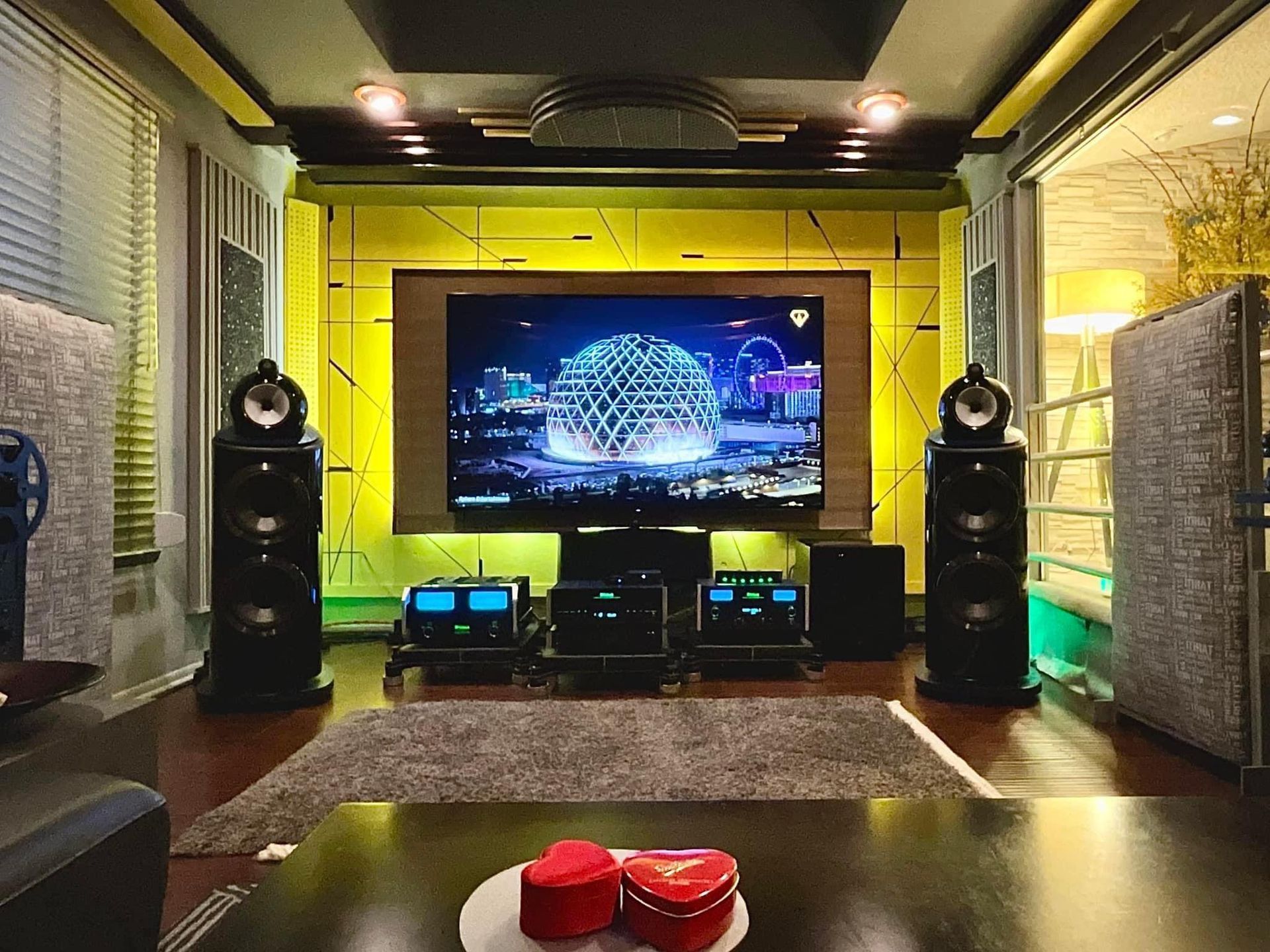 Home theater with large screen, speakers, and audio equipment; yellow, black, and gray color scheme.