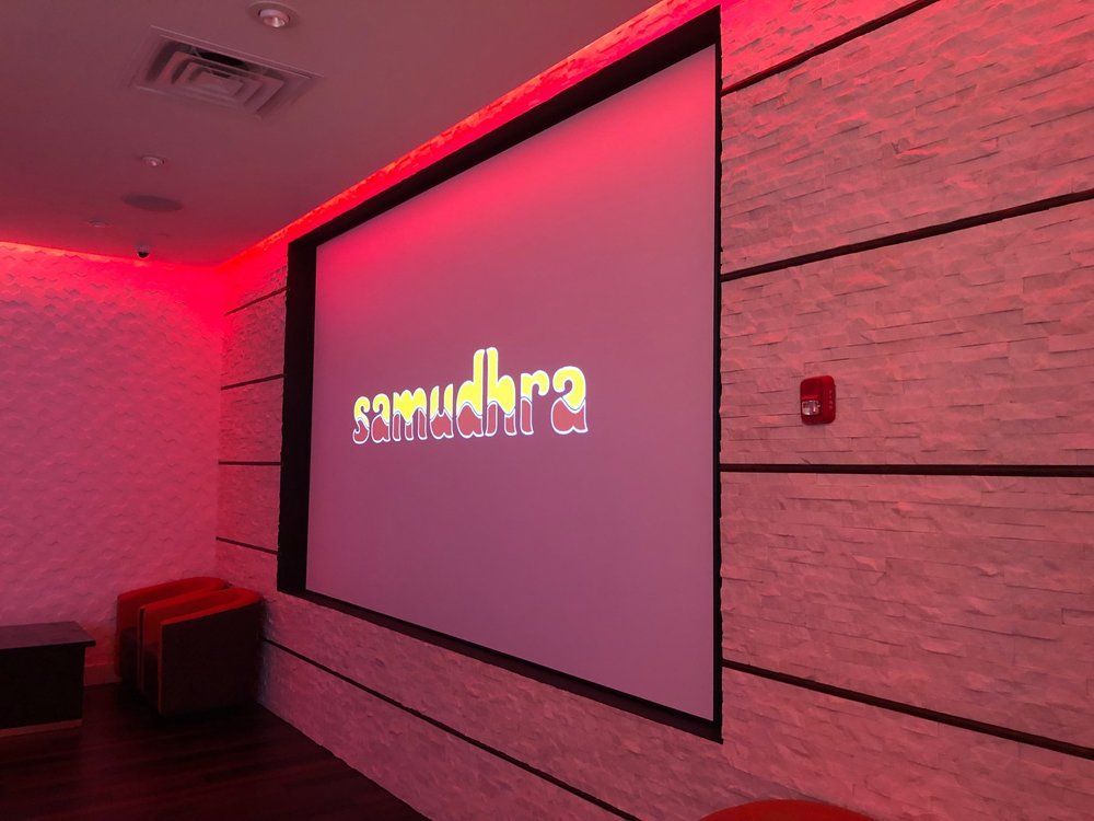 Red-lit room with large screen displaying 