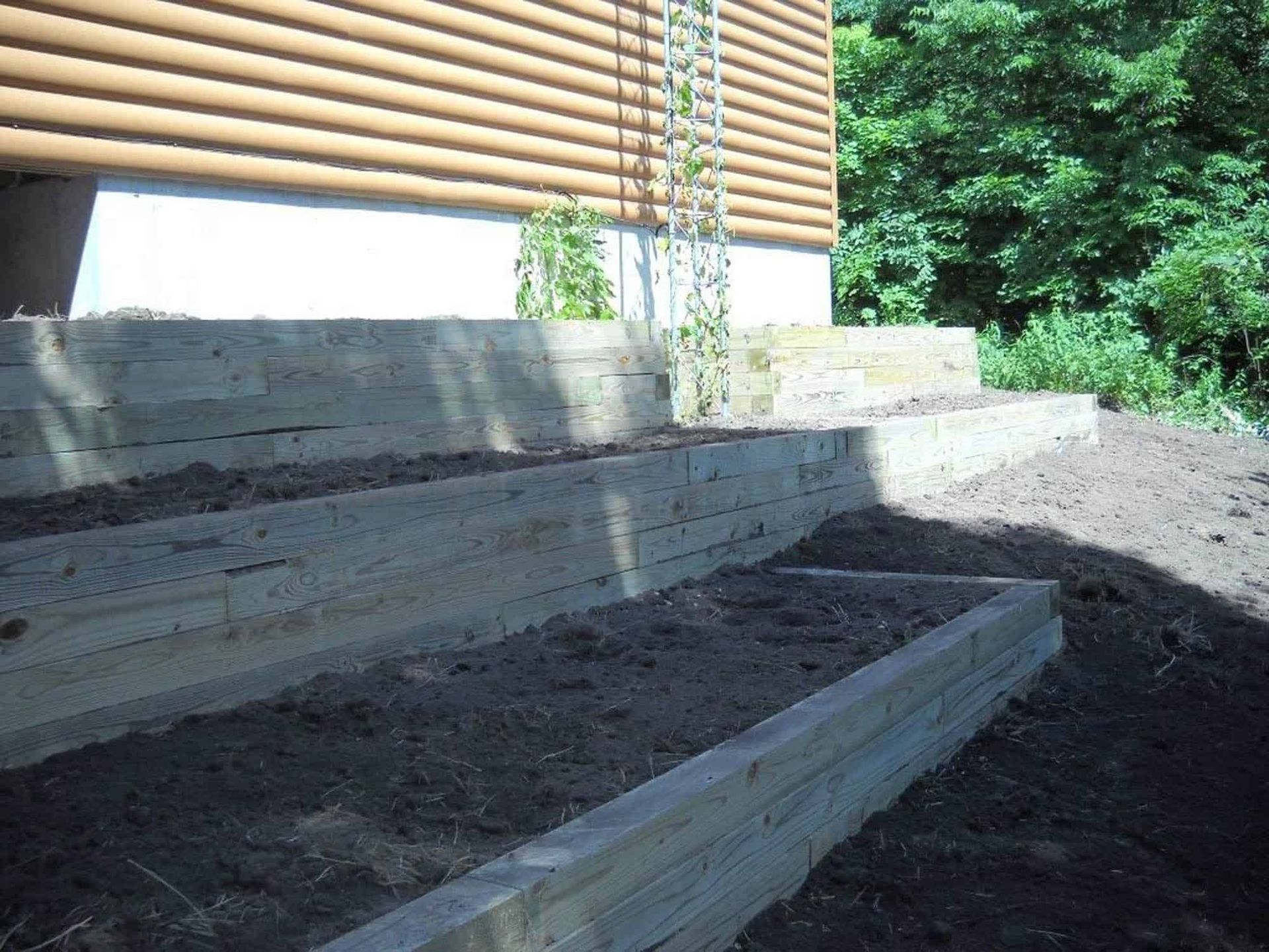 A house with a wooden siding and a few planters in front of it