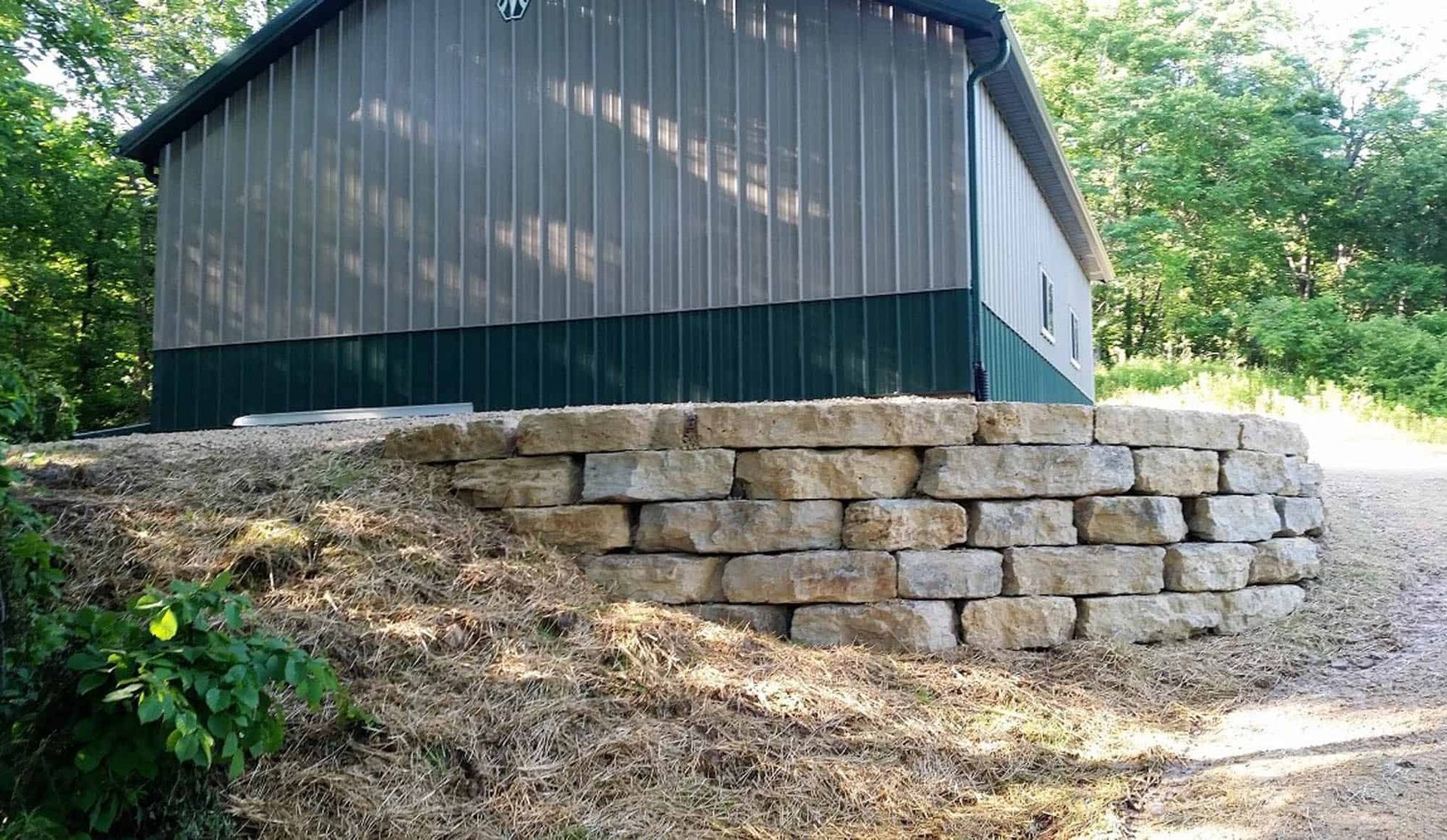A large building with a stone wall in front of it.