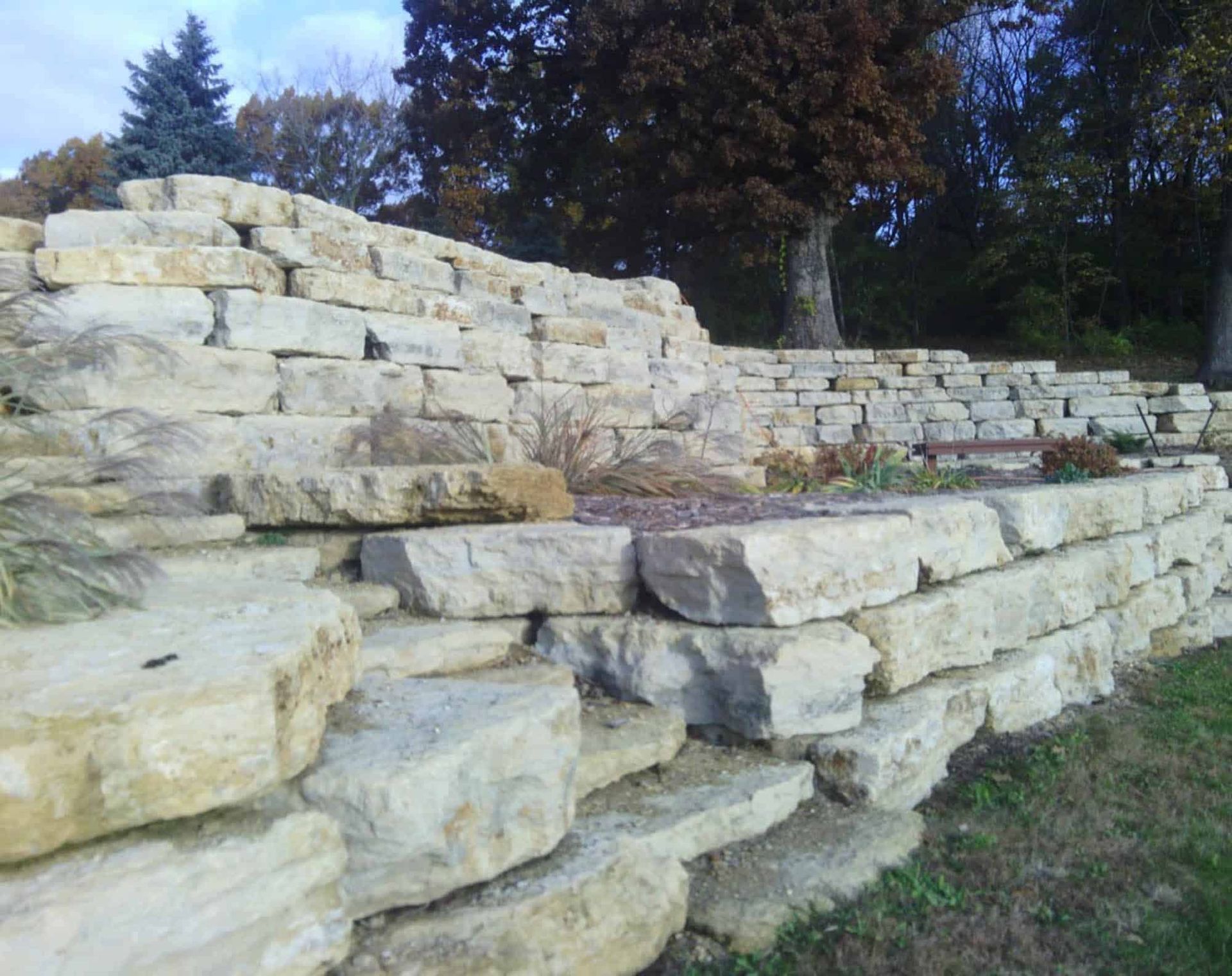 A large stone wall with trees in the background