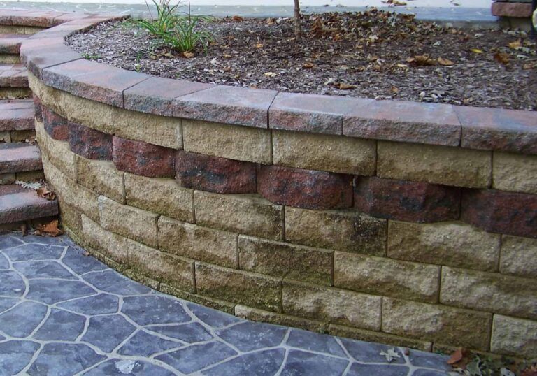 A brick wall with a planter on top of it