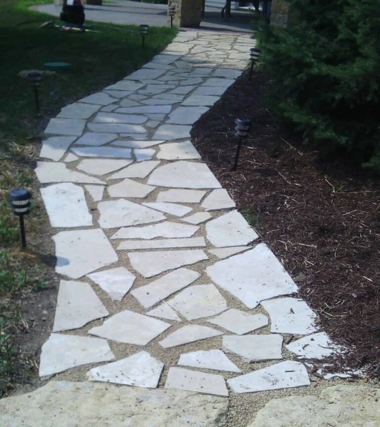 A stone walkway with a few lights on the side