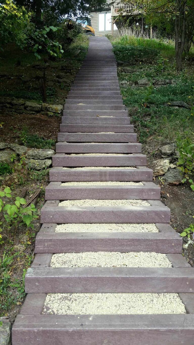 A set of stairs leading up to a house in the woods.
