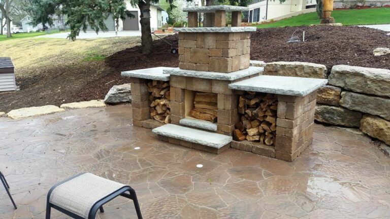 There is a fireplace with wood in it on the patio.