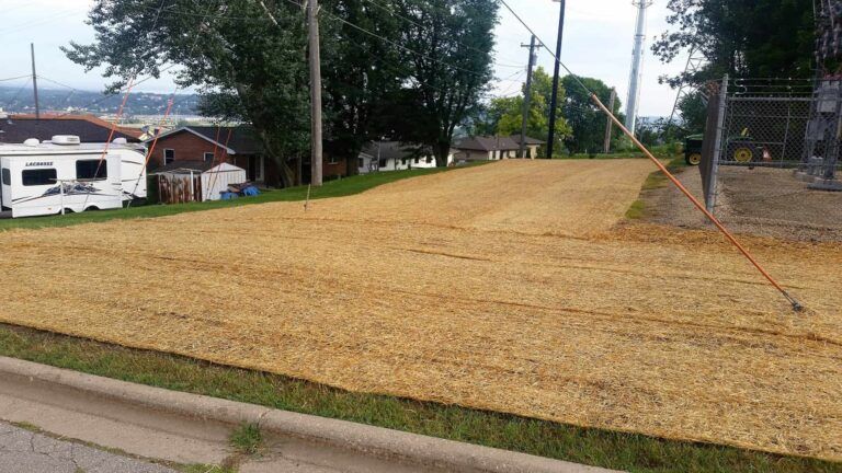 A large pile of dirt is sitting on the side of a road.