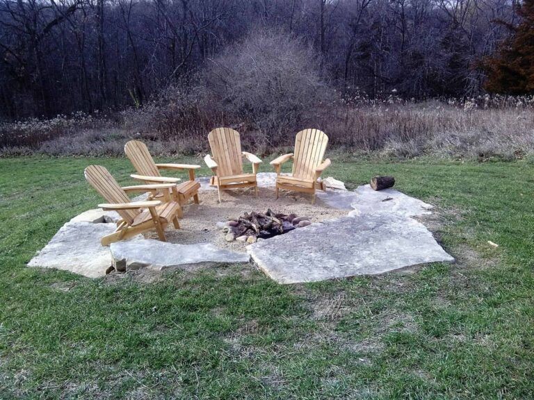 A group of lawn chairs are sitting around a fire pit.