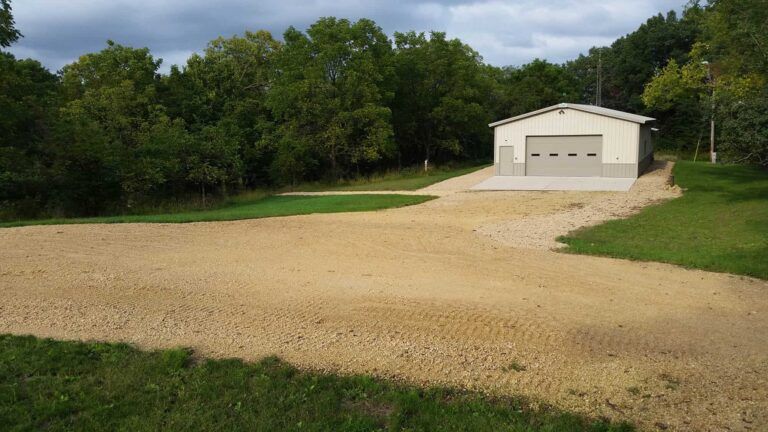 There is a garage in the middle of a dirt road.