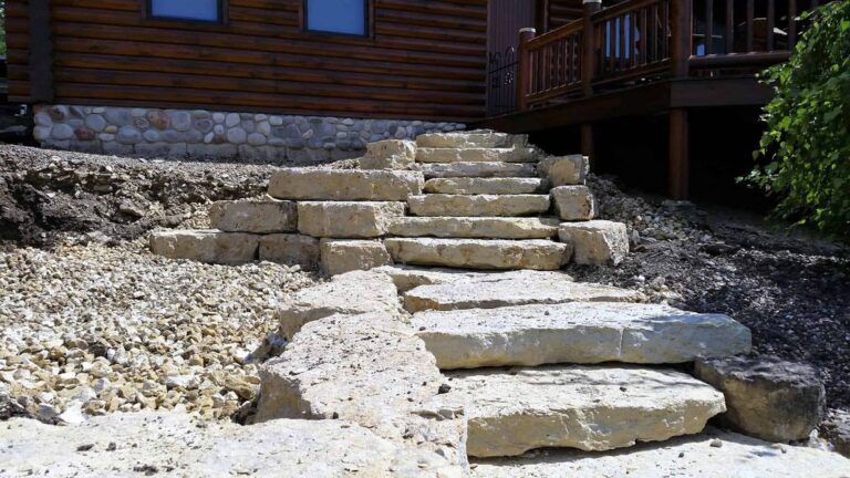 A set of stone stairs leading up to a log cabin.