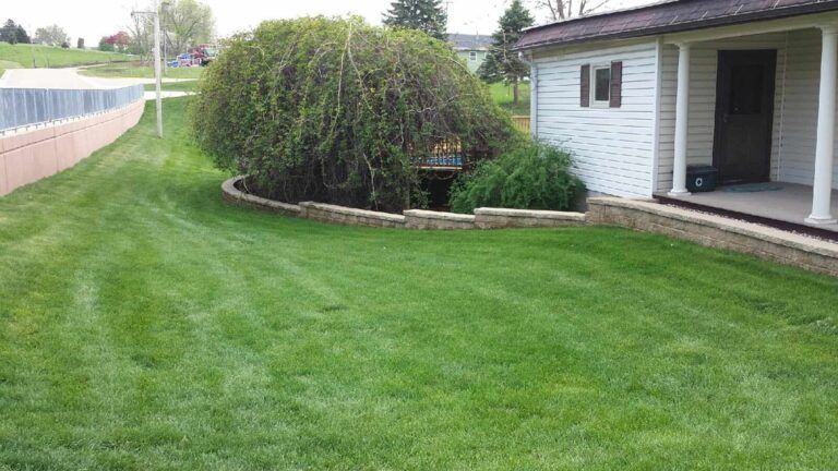 A white house with a lush green lawn in front of it.