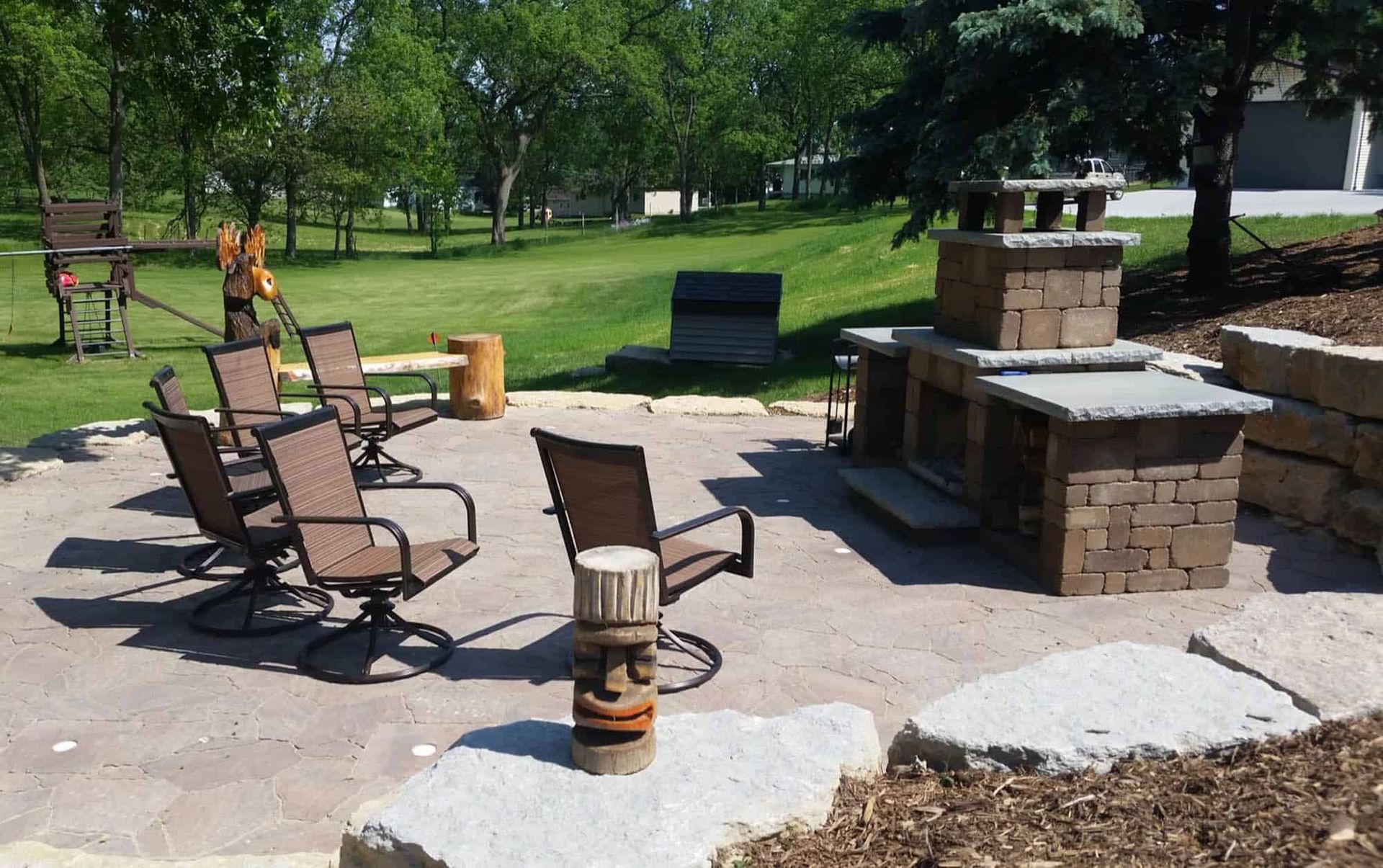A patio with chairs and a fireplace in the background