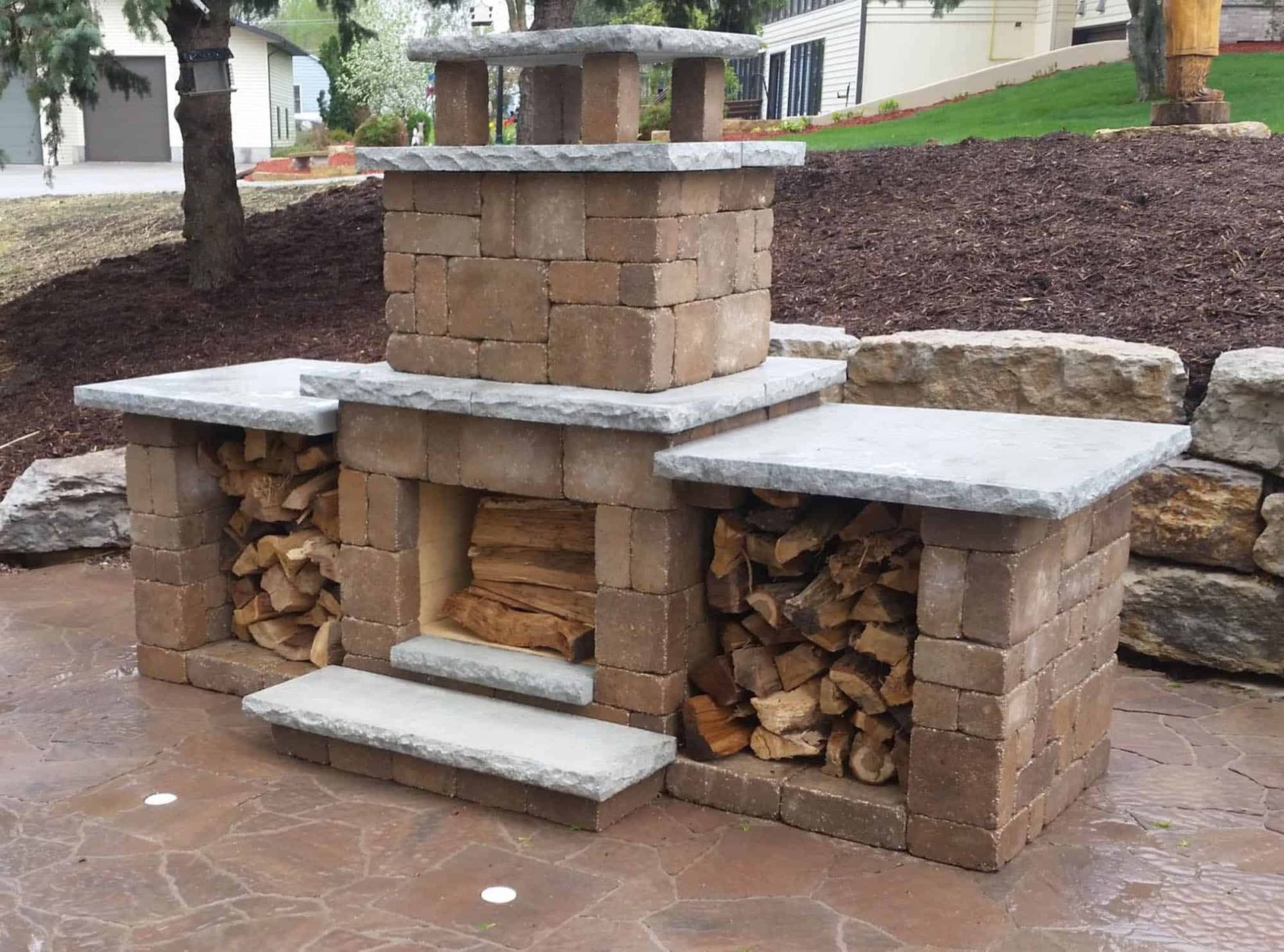 A brick fireplace with a stack of logs underneath it