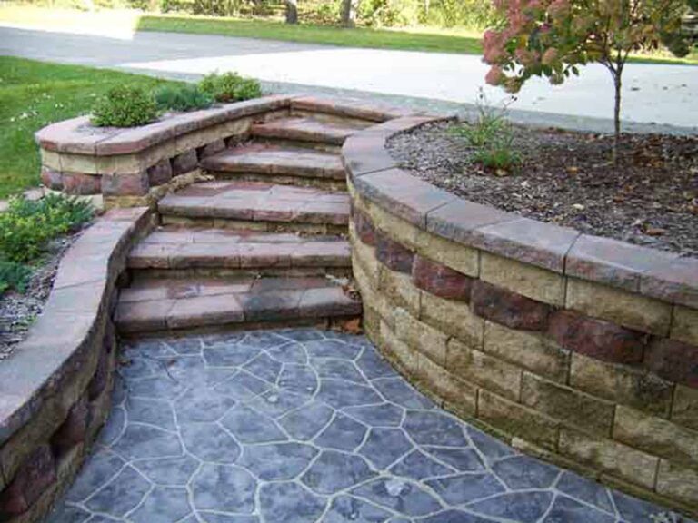 A set of stairs leading up to a brick wall.