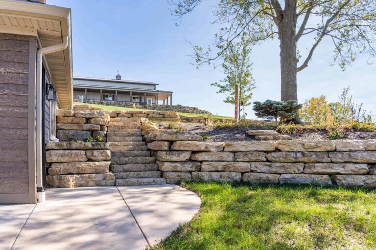 There is a stone wall in the backyard of a house.
