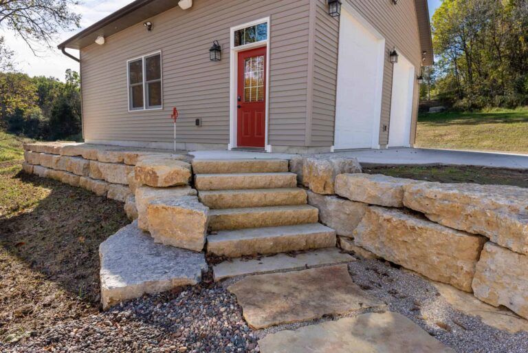 A house with a red door and stairs leading up to it.