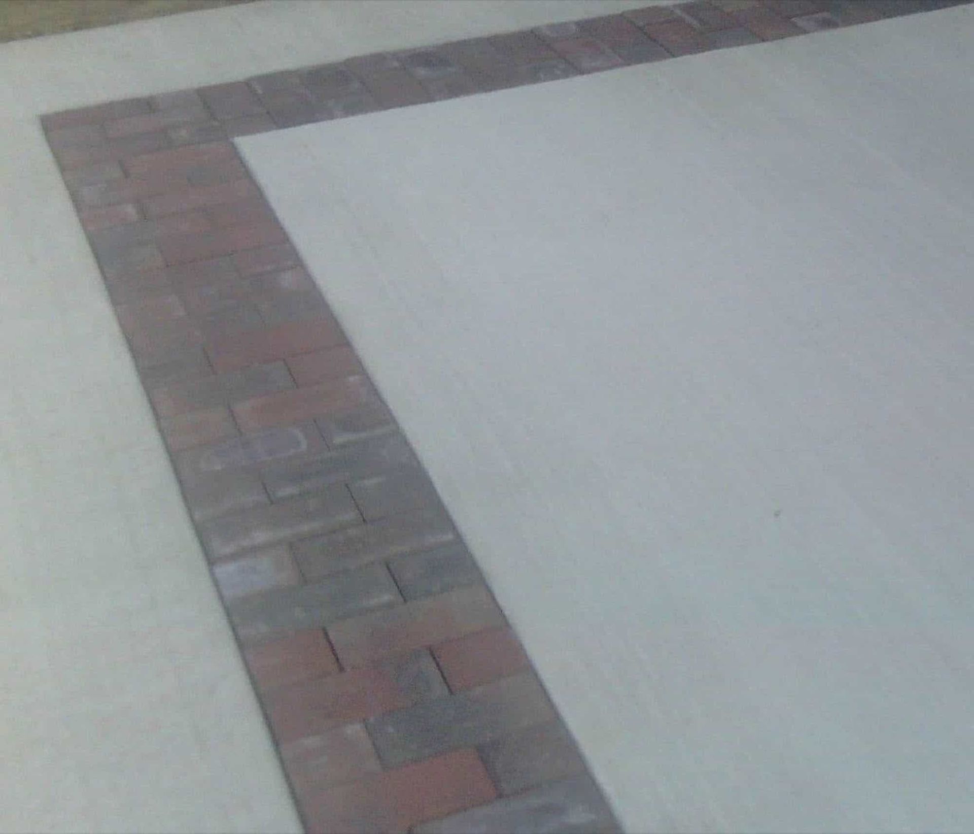 There is a brick border on the side of the road.