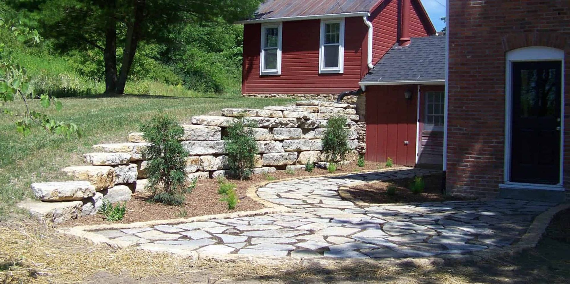 A red brick house with a stone walkway leading to it