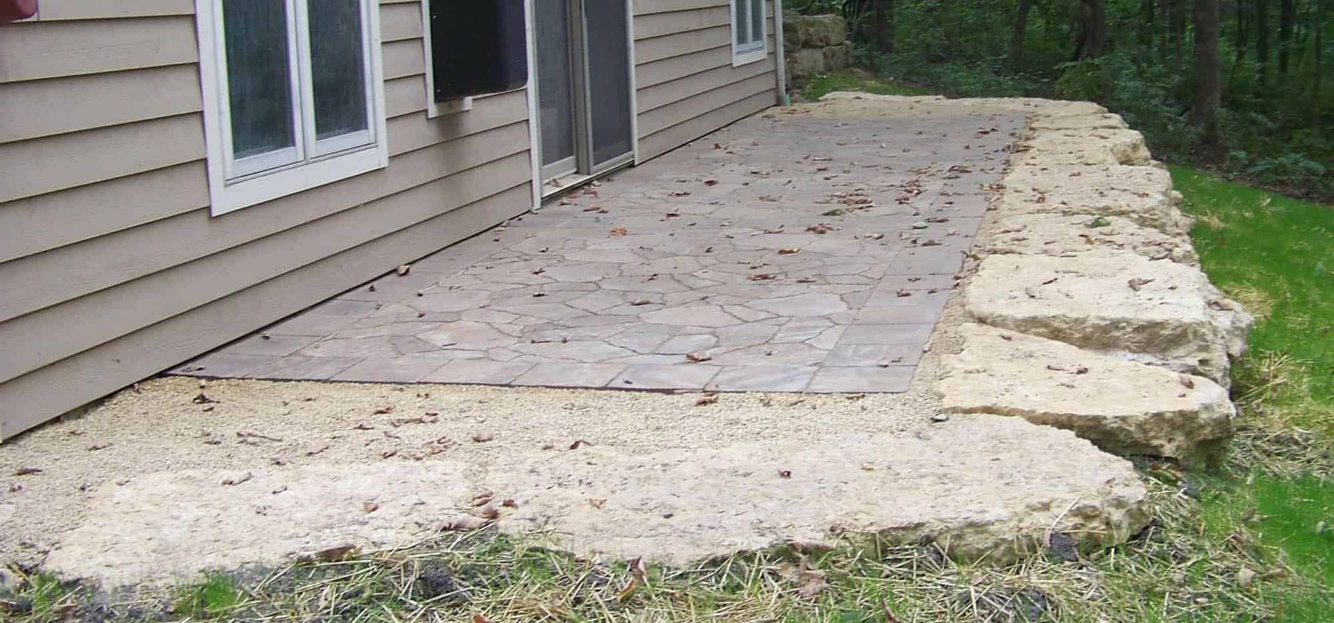 A house with a stone patio in front of it