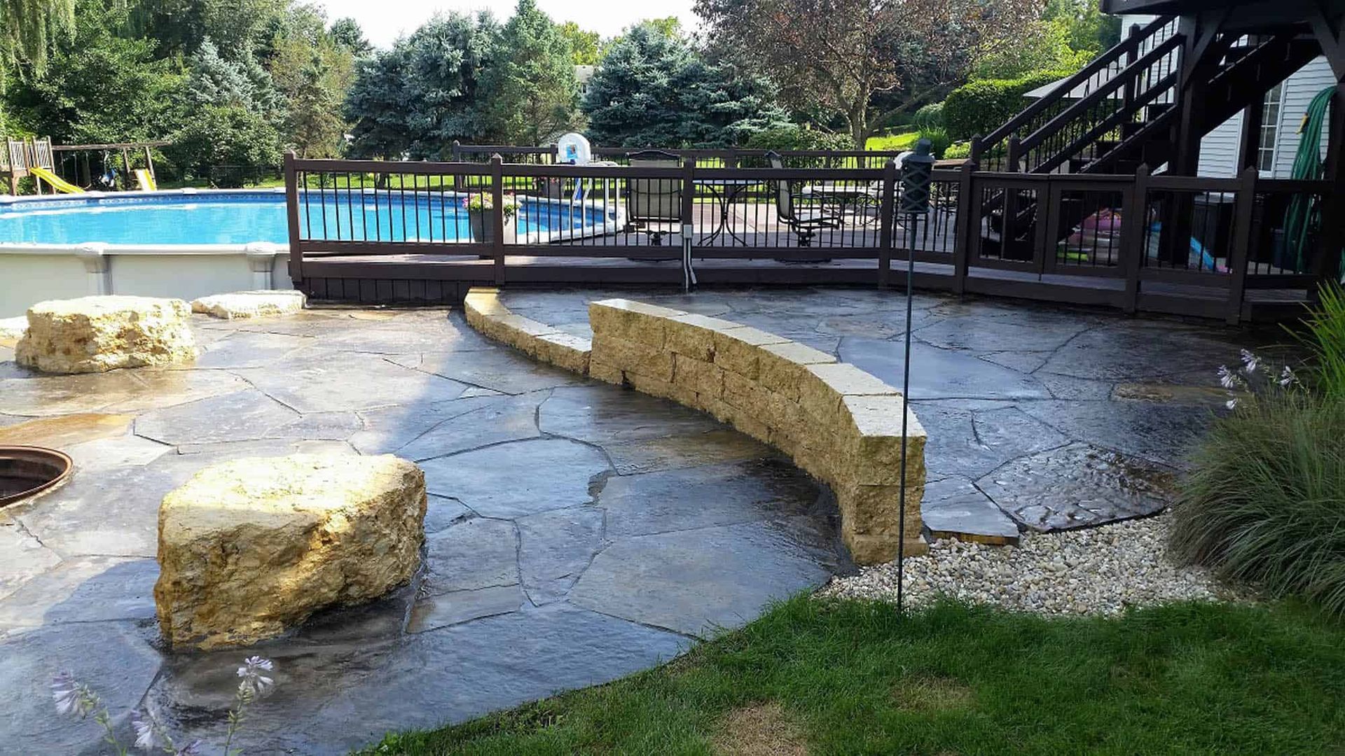 A patio with a swimming pool in the background
