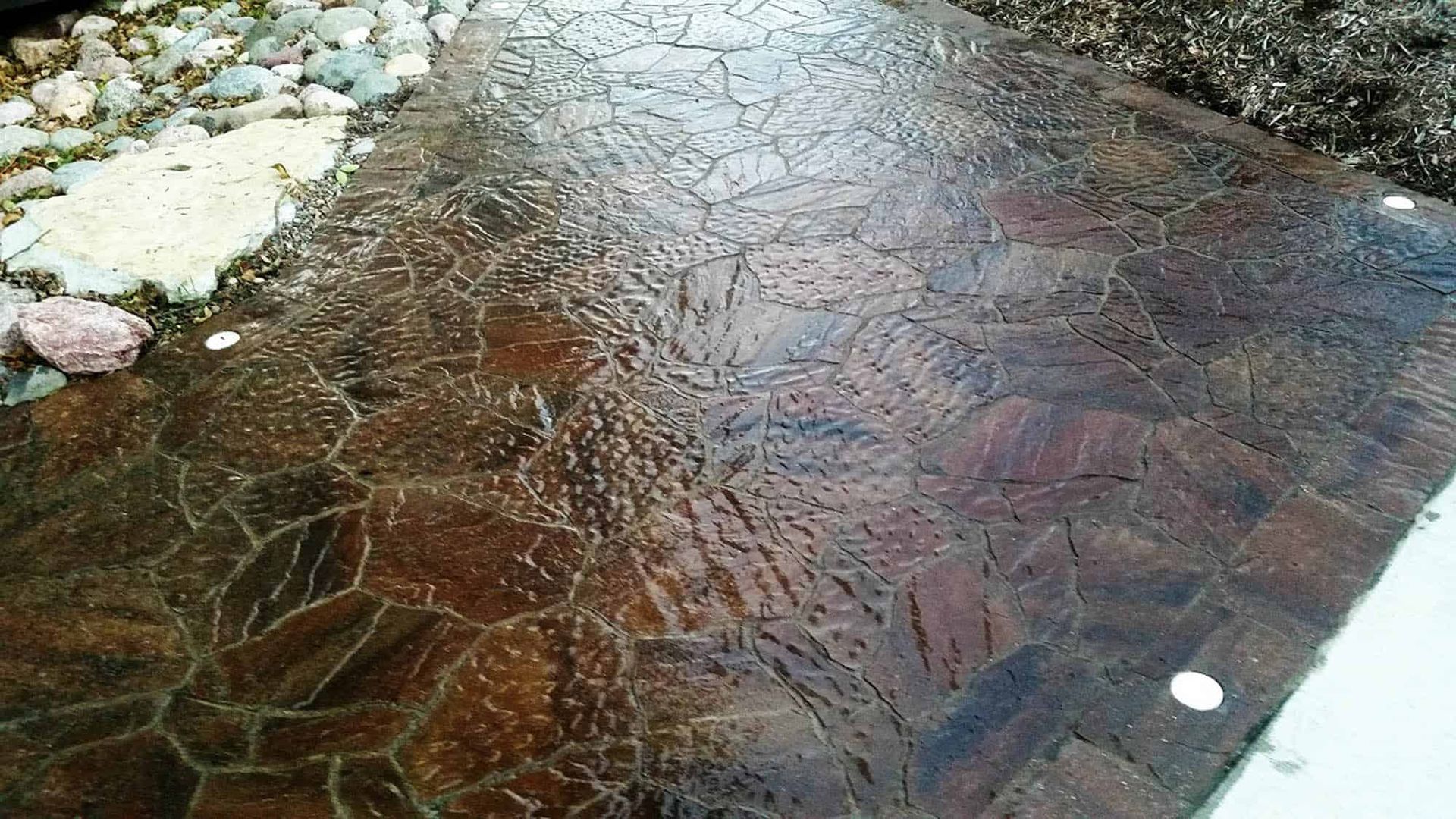 A stone walkway with a pattern of leaves on it