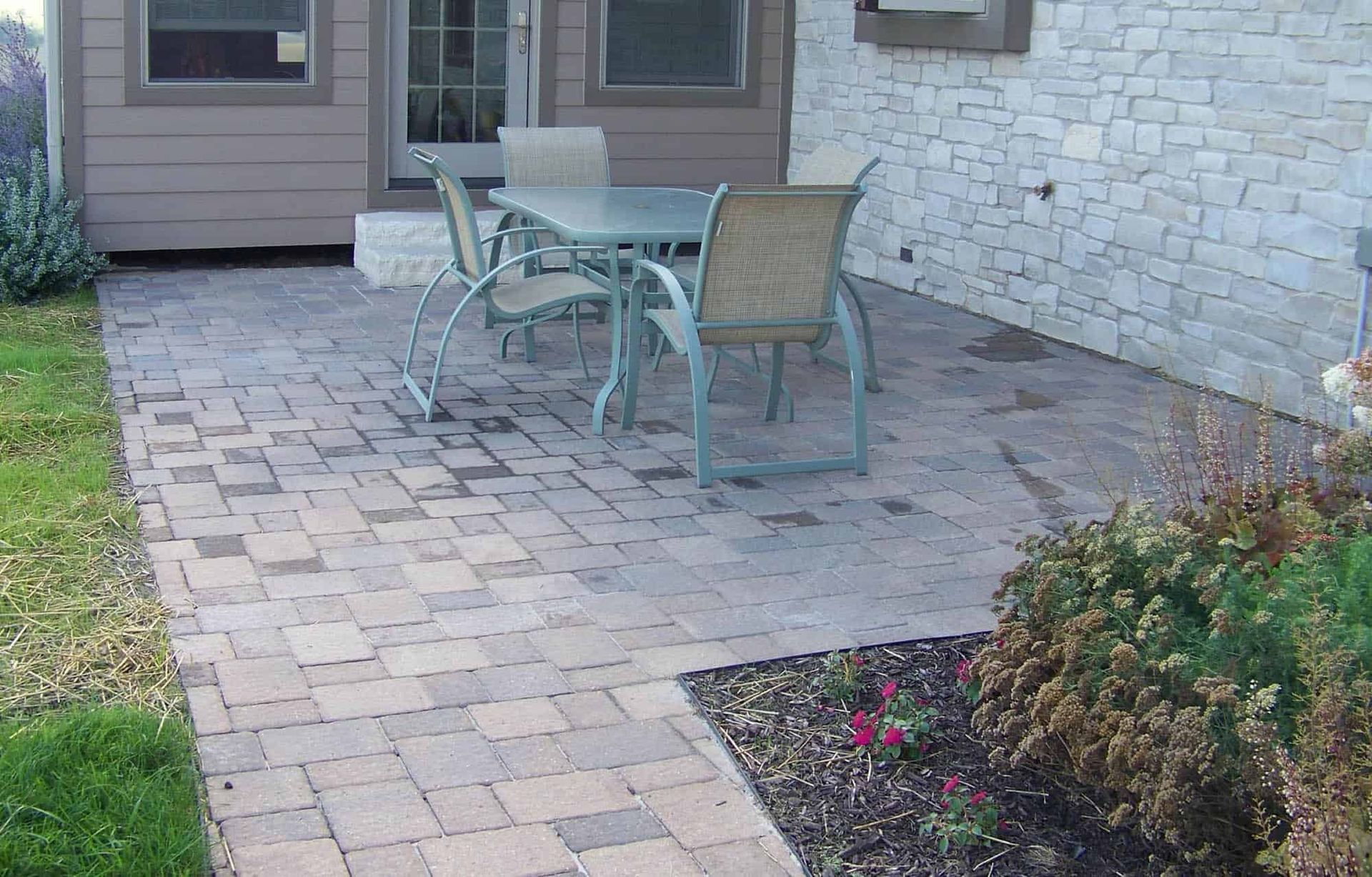 A patio with a table and chairs in front of a house