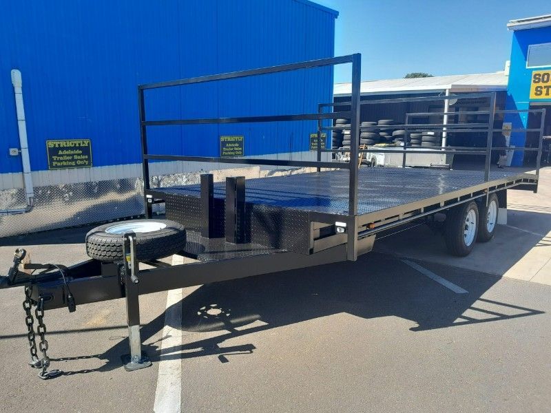 A Flatbed Trailer is Parked in a Parking Lot in Front of a Building — Voyager Trailers in Humpty Doo, NT