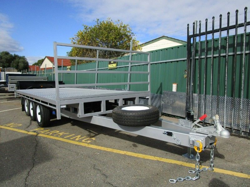 A Flatbed Trailer is Parked in a Parking Lot Next to a Fence — Voyager Trailers in Humpty Doo, NT