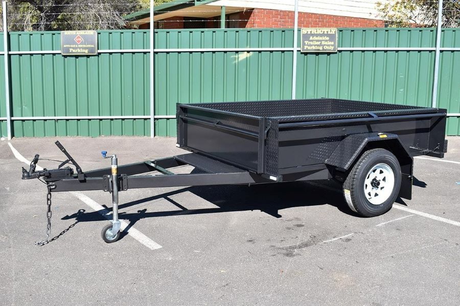 A Black Trailer is Parked in a Parking Lot in Front of a Green Fence — Voyager Trailers in Yarrawonga, NT