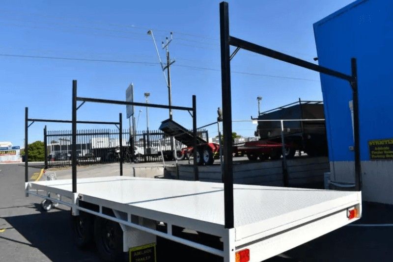 A White Trailer is Parked in Front of a Blue Building — Voyager Trailers in Howard Springs, NT