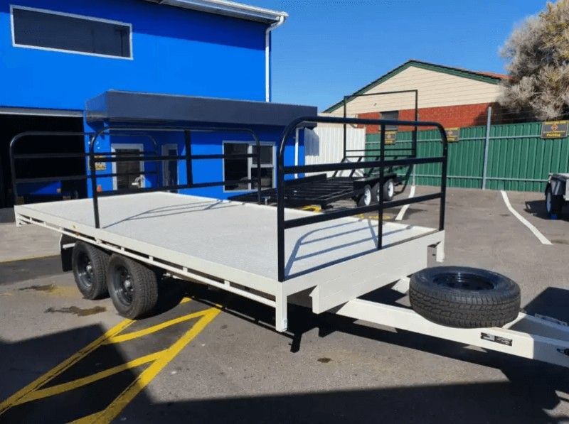 A Trailer is Parked in a Parking Lot in Front of a Blue Building — Voyager Trailers in Yarrawonga, NT