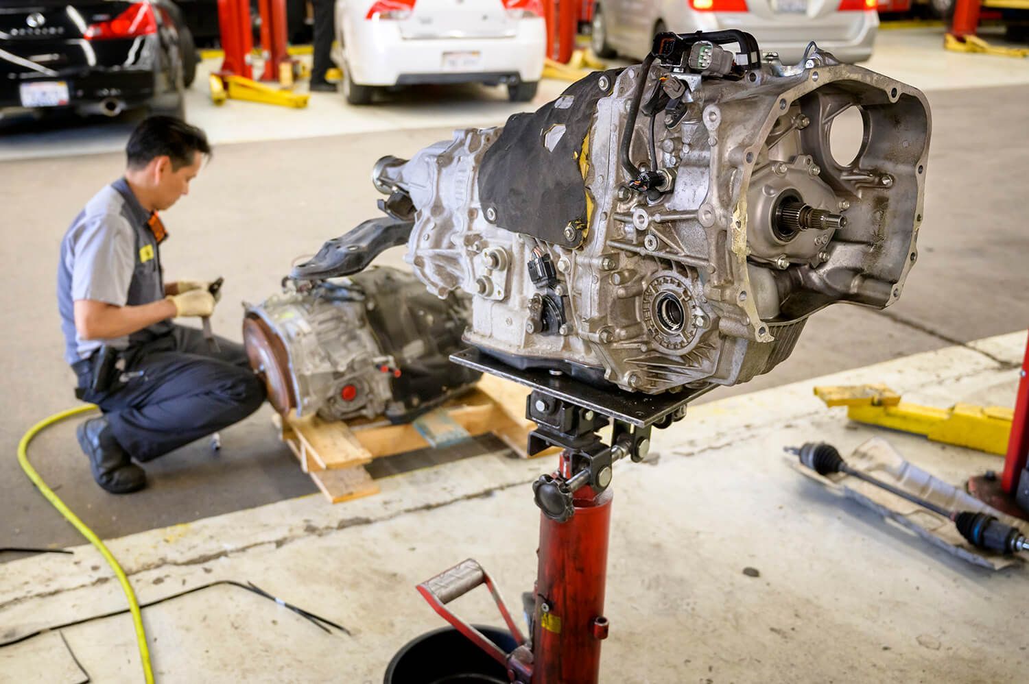 Mechanic working on a car engine mounted on a stand in an auto repair garage | Adaptive Fleet Management