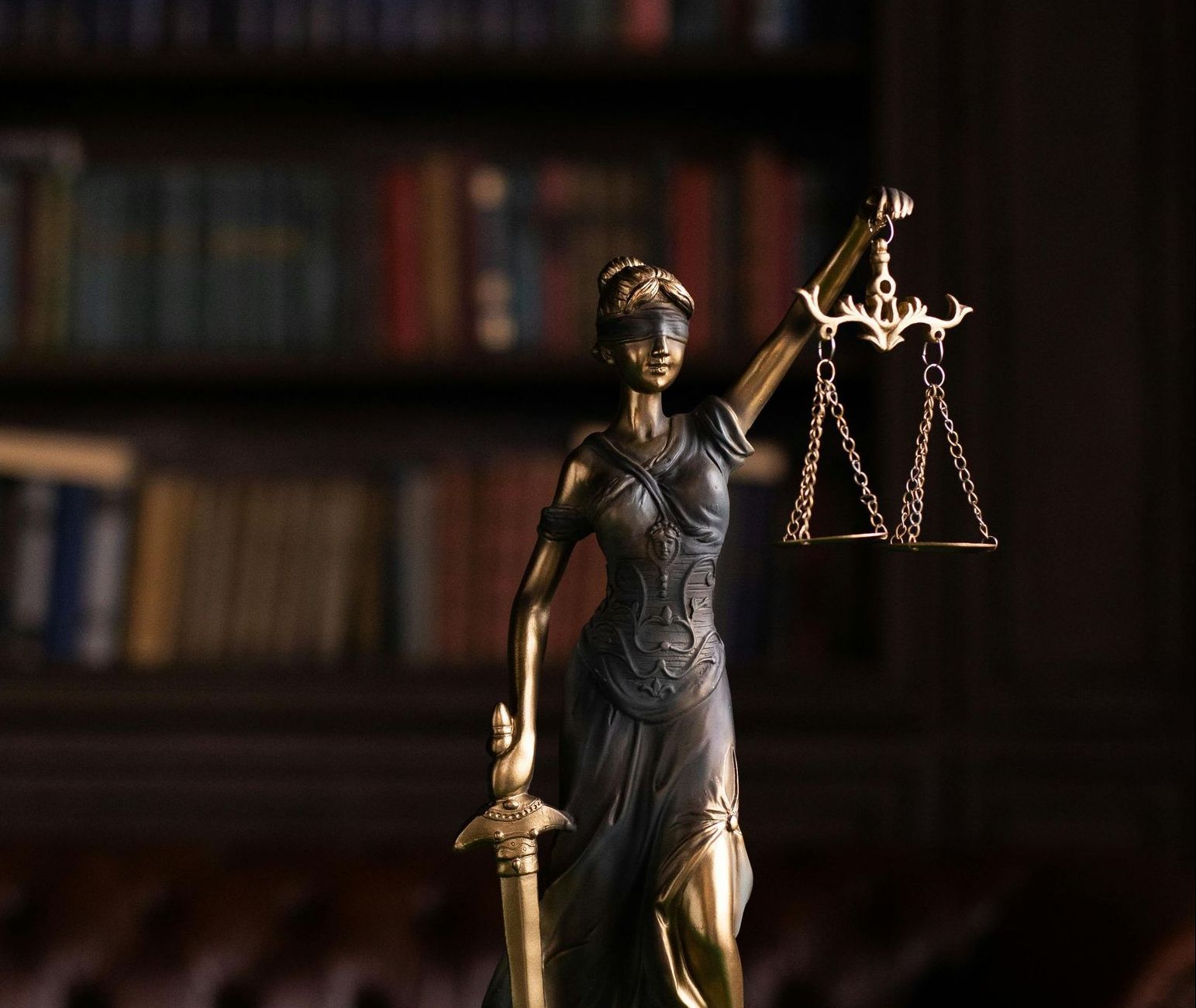 statue of a woman in robes holding a sword and scales that are balanced