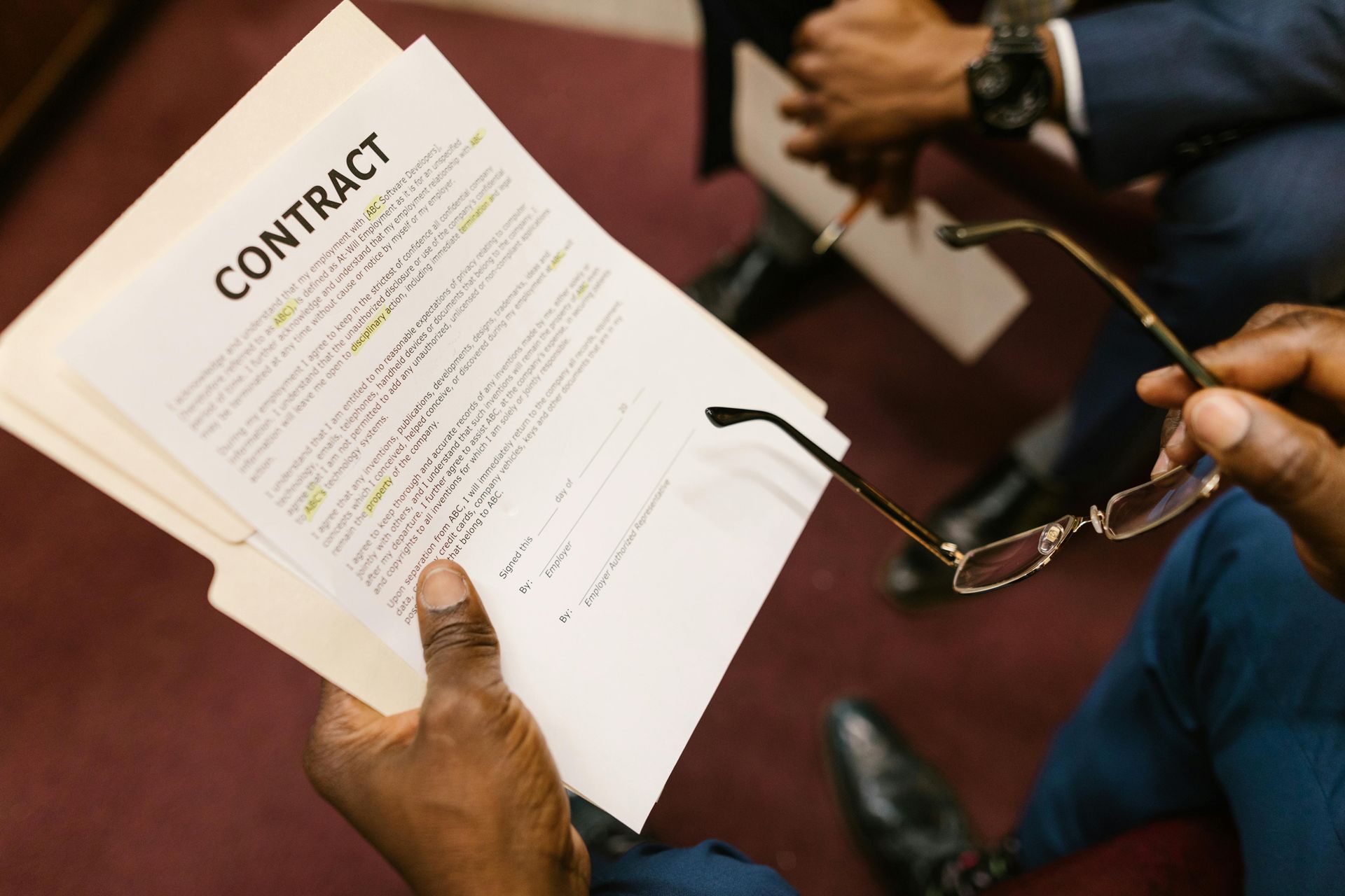 A person is holding a piece of paper with the word contract on it.