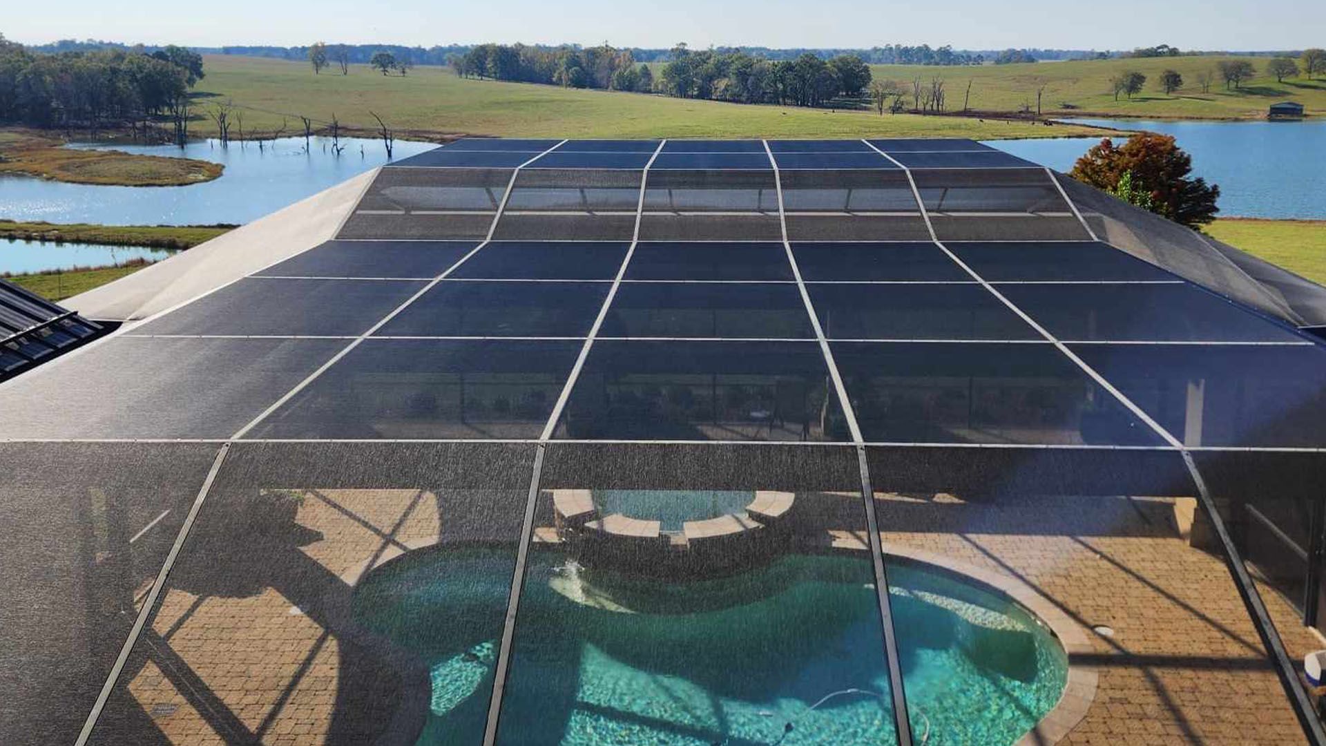 A swimming pool with a fence around it and a view of a lake.