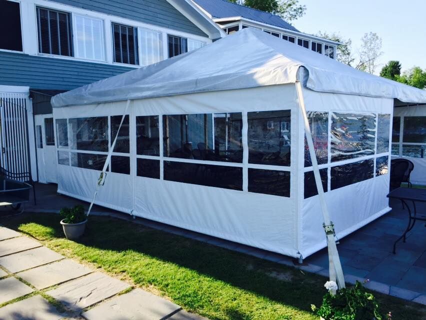 A white tent is sitting in front of a house