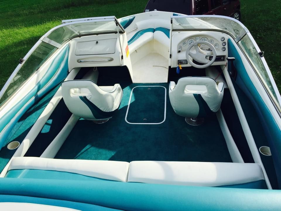 A blue and white boat is parked in the grass