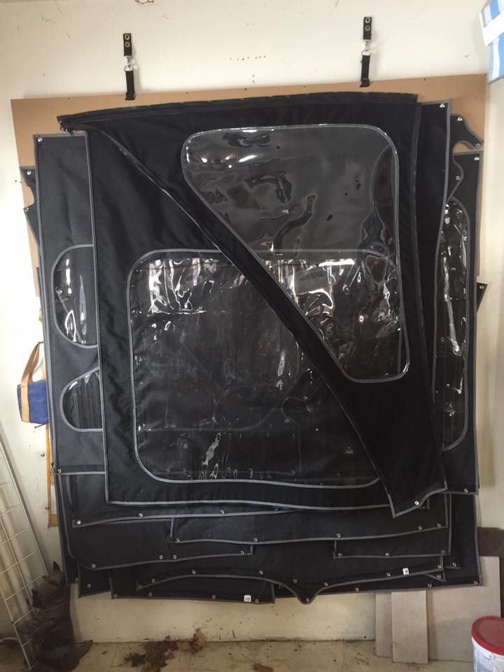 A black tarp with clear windows is hanging on a wall