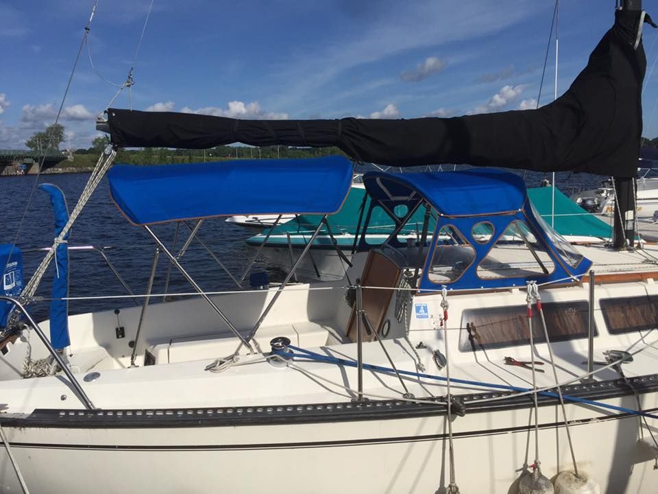 A sailboat with a blue canopy is docked in the water