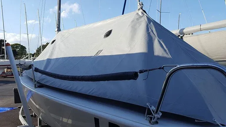A boat with a cover on it is sitting on a dock.