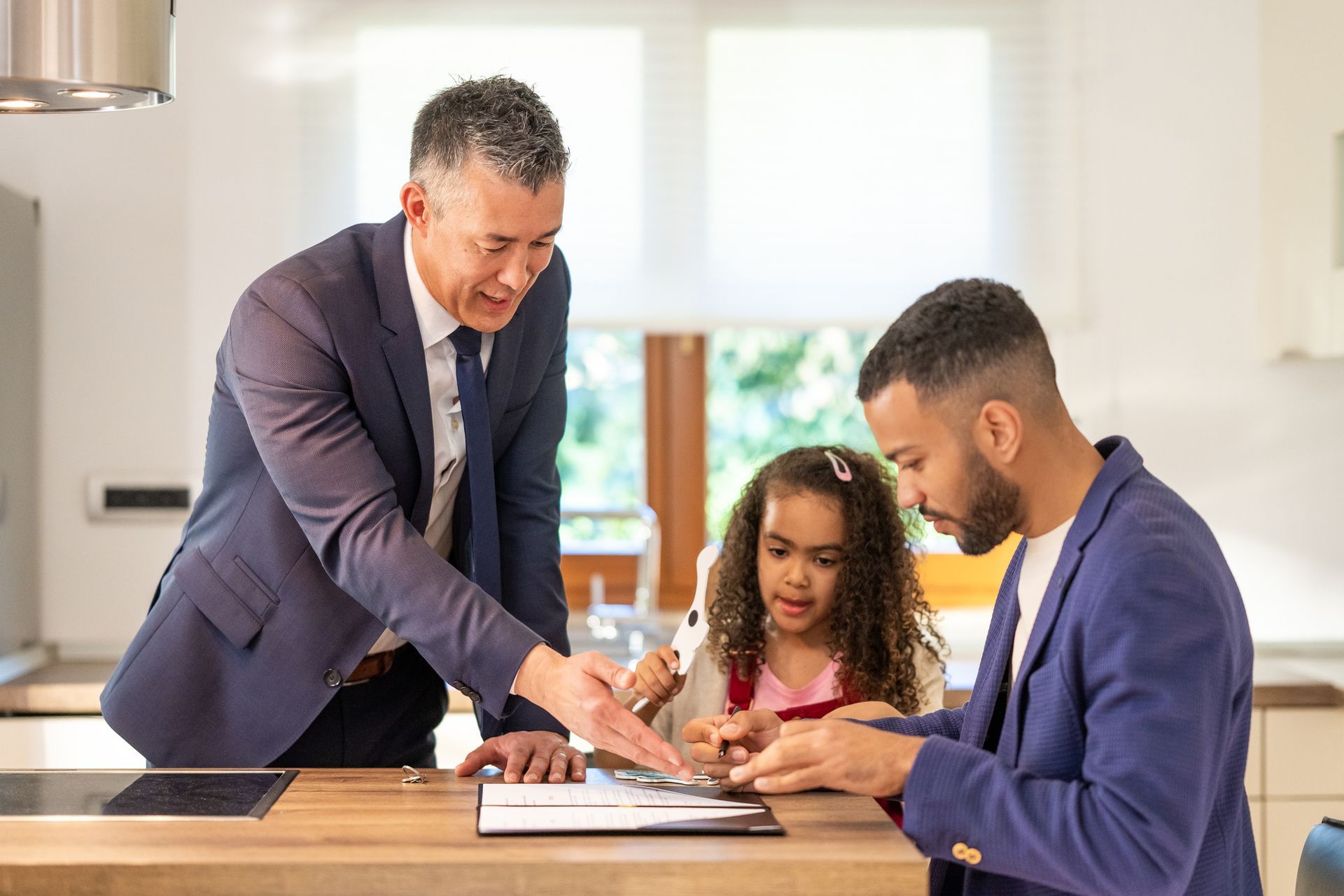 A child custody attorney guiding a client to sign documents with his daughter next to him.