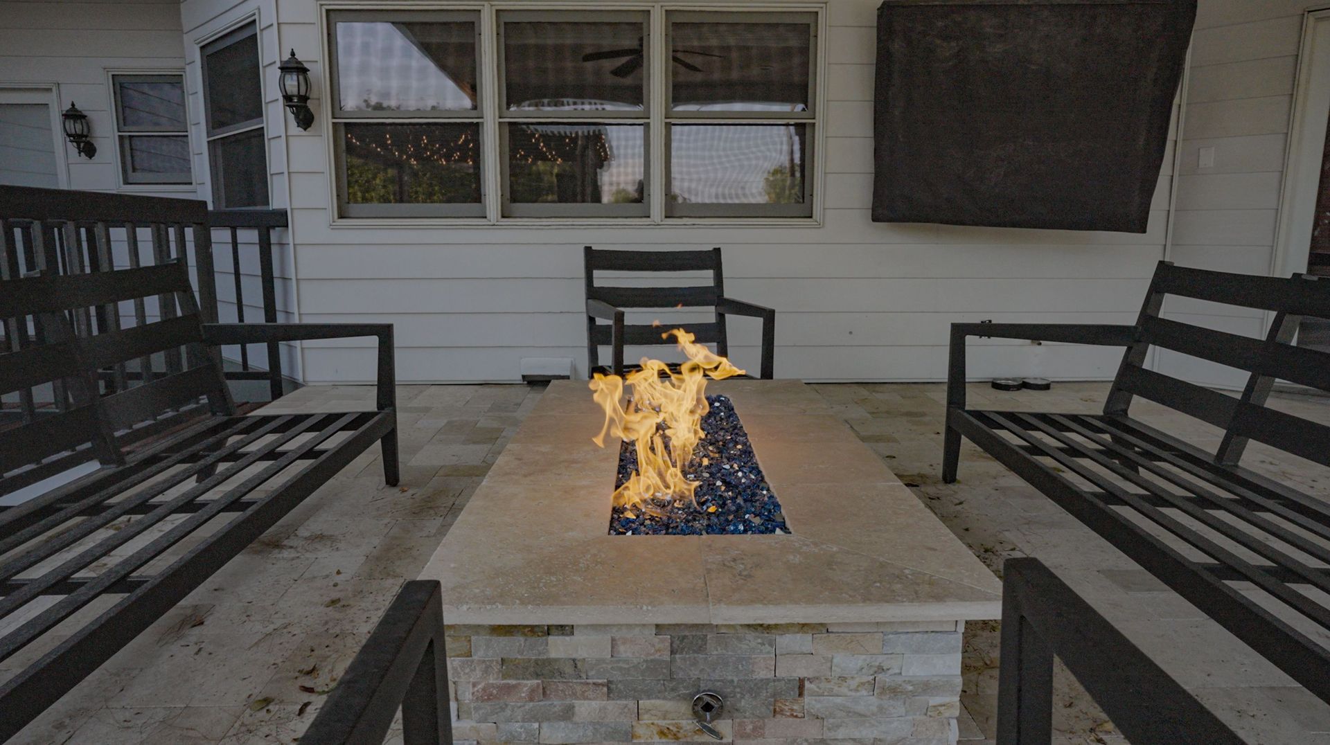 There is a large swimming pool in the backyard of a house.