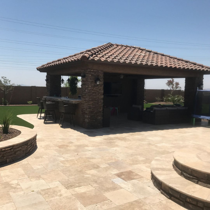 A gazebo with a tiled roof and a patio in front of it