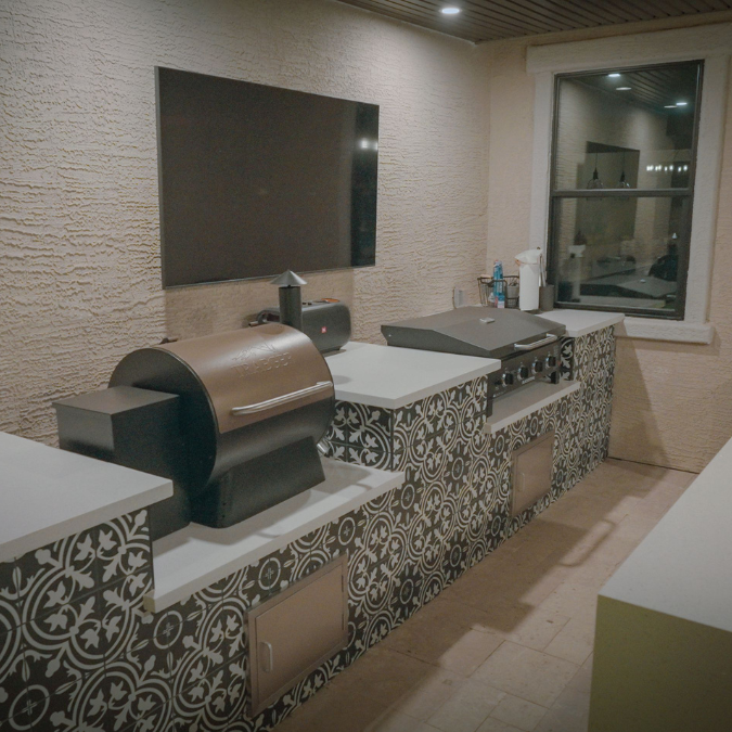 A kitchen with a grill and a flat screen tv