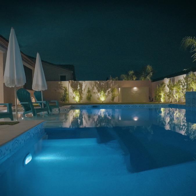 A large swimming pool is lit up at night