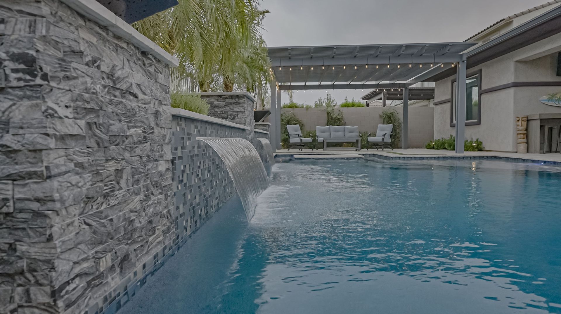 There is a waterfall in the middle of the pool.